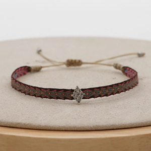 Macro shot of boho woven strap bracelet with a sparkling crystal diamond charm