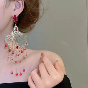 Detail of red crystal tassel earrings with silver filigree on an Asian model