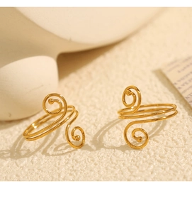 Macro shot of gold-plated double-layer spiral open ring on a textured background