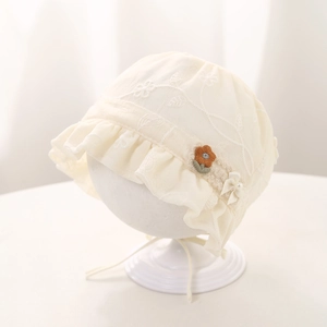 Detailed embroidery and pearl bow accent on a cream baby lace bonnet sun hat