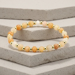 Macro shot of 4mm faceted Amazonite stones with golden metal spacer beads on an elastic bracelet
