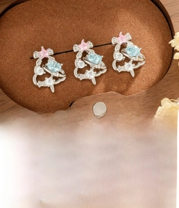 Detail of Christmas tree stud earring set with pink star and blue heart zircon in box