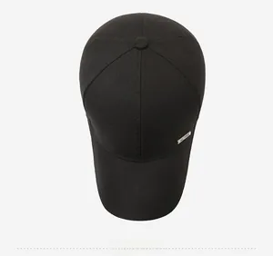Top-down view of a black twill cotton baseball cap with a metal logo side detail