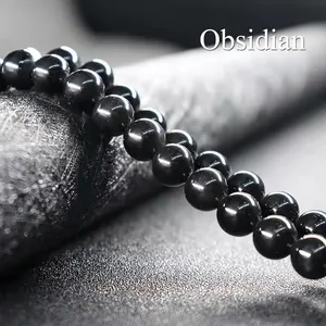 Macro shot of polished natural black obsidian beads showing uniform texture and glossy finish
