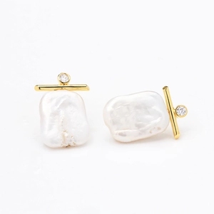Detailed view of baroque pearl earrings with gold-plated bar and sparkling zircon accents