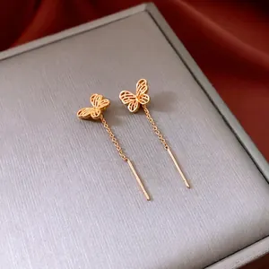 18K gold plated butterfly drop earrings on grey jewelry box with red silk background