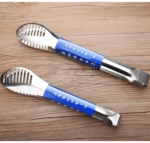 Detail of stainless steel food tongs with hollowed-out striped head on wood background