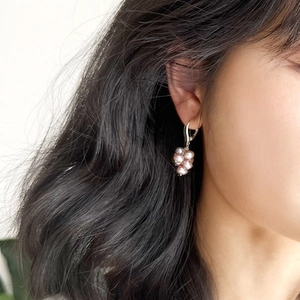 Macro detail of natural freshwater pearl grape cluster earrings on a silver hoop