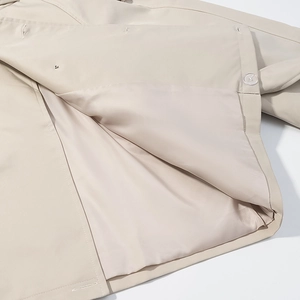 Gros plan détaillé de la doublure de trench-coat beige avec couture et bouton