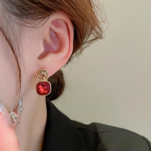 Close-up of vintage square red gemstone earrings with champagne stones and gold edges