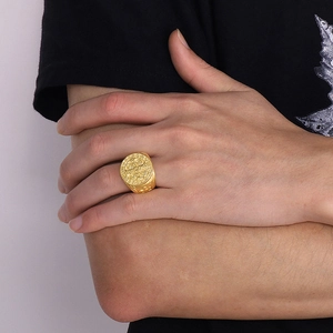 Dettaglio dell'anello medaglia di San Benedetto in oro indossato da un modello sull'indice