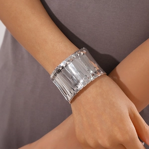 Detailed view of irregular wide silver metal cuff bracelet with vertical mirrored stripes