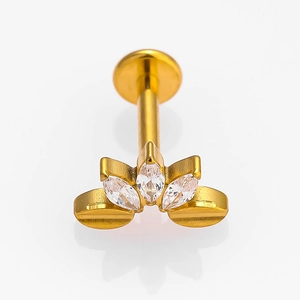 Macro shot of gold G23 titanium labret stud with three marquise-cut clear zircons