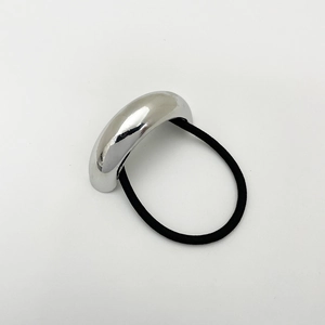 Detail of minimalist silver alloy hair tie with sleek metal arc and black elastic band