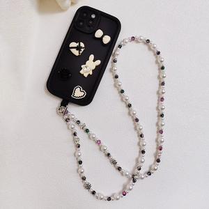 Detail of beaded phone strap with white pearls and heart charms on a black phone case