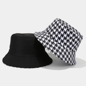 Cappello da pescatore reversibile da donna con motivo pied de poule nero e bianco alla moda