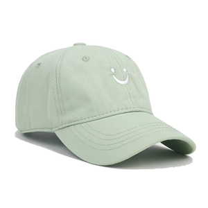 Detailed view of the mint green cotton baseball cap with white smiley face embroidery