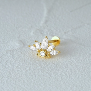 Macro shot of gold crown-shaped earring featuring marquise and round cut crystals