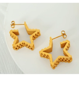 Macro shot of gold hollow star earrings featuring unique wavy serrated edge detailing