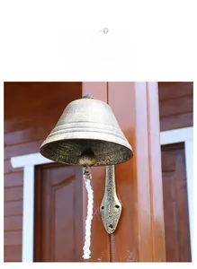 Macro detail of industrial cast iron doorbell with leaf mount and white pull rope
