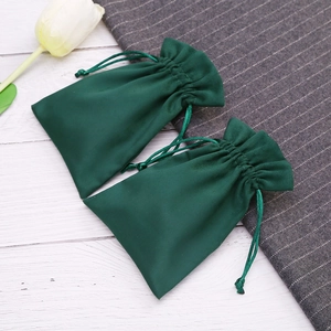 Detailed view of dark green velvet drawstring pouches for jewelry storage and gift packaging