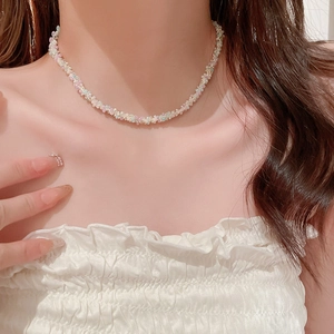 Collier ras du cou en perles colorées pastel porté par un mannequin sous lumière douce