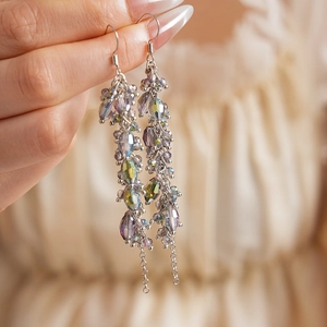 Close-up of bohemian silver drop earrings with faceted iridescent crystal beads and tassels