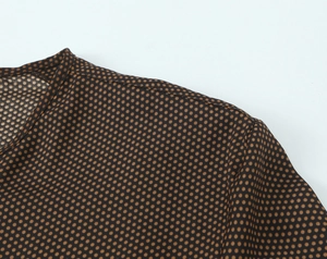 Détail de la robe marron à pois montrant le tissu en maille et les coutures du col