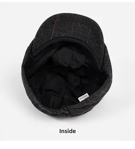 Detail view of the gray herringbone newsboy cap interior lining and woven label