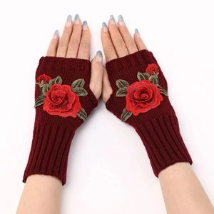 Close-up of knit fingerless gloves in wine red with detailed 3D rose flower embroidery
