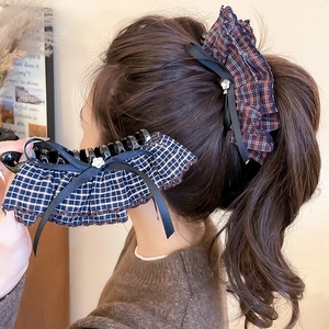 Detail of vintage plaid fabric hair clips with ruffles and delicate black ribbon bows