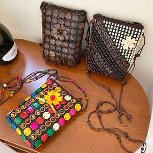 Detailed view of handmade bohemian coconut shell woven bags with floral bead decorations
