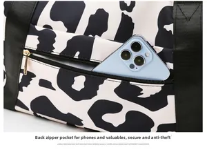 Detail view of anti-theft back zipper pocket on cow print travel bag with phone storage