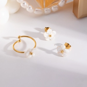 Nahaufnahme des goldenen Blumenschmuck-Sets mit weißen Blütenblättern und Goldperlen