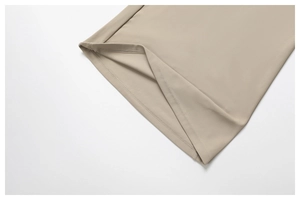Vue détaillée du vêtement de yoga beige montrant l'ourlet à double aiguille et le tissu technique