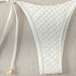 White textured bikini bottom with side ties and seashell charms for beachwear
