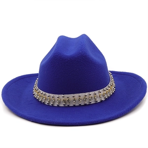 Detail of royal blue wool fedora featuring white ribbon with silver studs and rhinestones