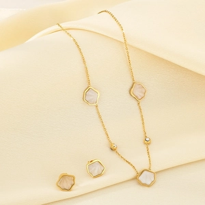 Elegant gold necklace and earrings set with white shell inlays and sparkling accents