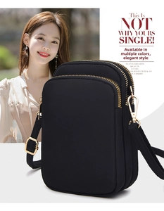 Detailed view of black multi-layer nylon crossbody bag with three zipper compartments