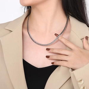 Minimalist silver titanium steel Cuban link chain necklace shown on a suit jacket model