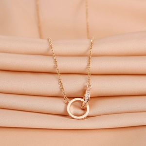 Rose gold interlocking double ring necklace with cubic zirconia on champagne silk fabric