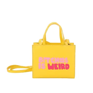 Yellow leather tote bag with pink street style lettering and adjustable strap