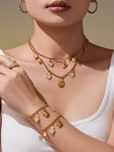 Gros plan détaillé du collier multicouche doré et des pendentifs cœur sur le mannequin