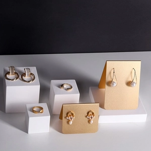 Elegantes Gold-Schmuckset mit Perlen und Ringen auf minimalistischen Displays