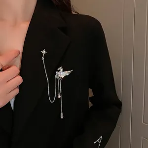 Silver Pegasus and starburst tassel brooch with rhinestones on a black suit jacket