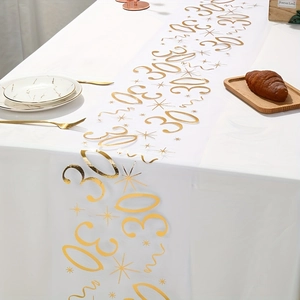 Detail of white mesh table runner with metallic gold 30th birthday stars and numbers