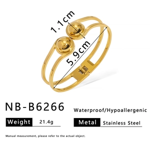 Detailed view of gold stainless steel open bangle with double bands and polished metal spheres