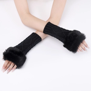 Detail of black cable-knit arm warmers with plush faux fur cuffs on a model