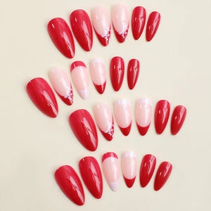 French red tip Christmas press-on nails with white flower patterns on almond shapes