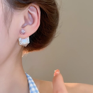 Close-up of elegant cubic zirconia earrings with pink studs and geometric white pendants